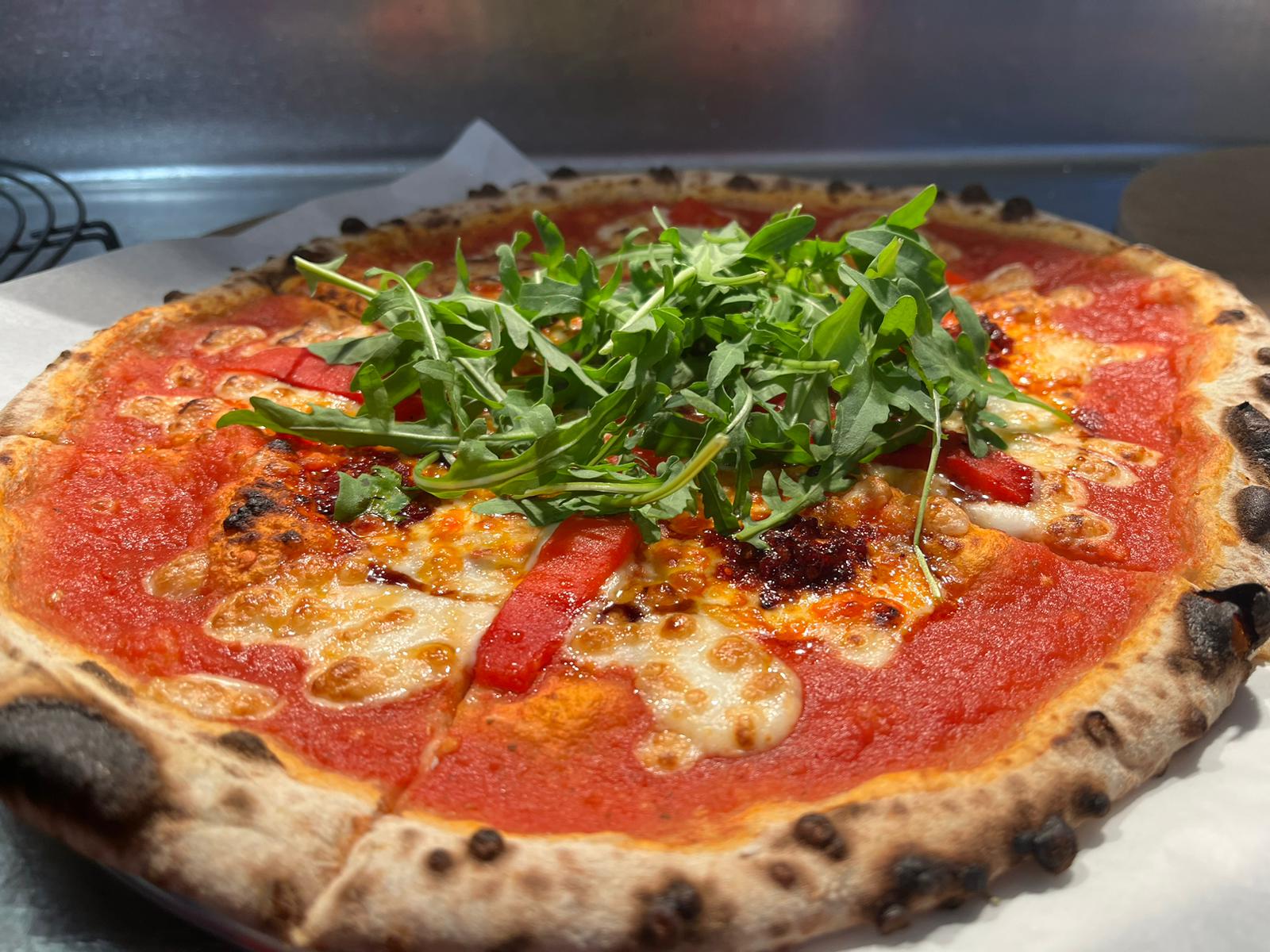 A stone-baked pizza topped with fresh rocket and red pepper at Luso in Cavan town