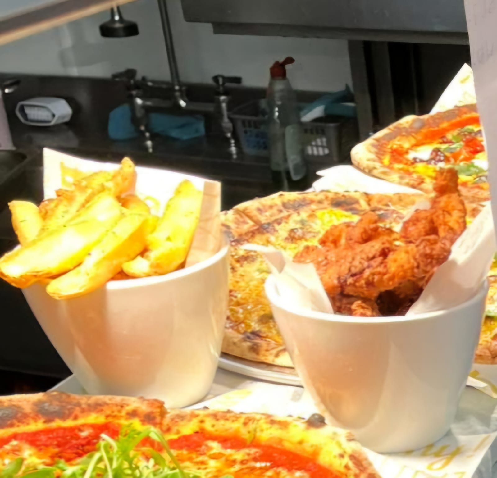 Pizzas, wedges and fried chicken ready to serve at Luso