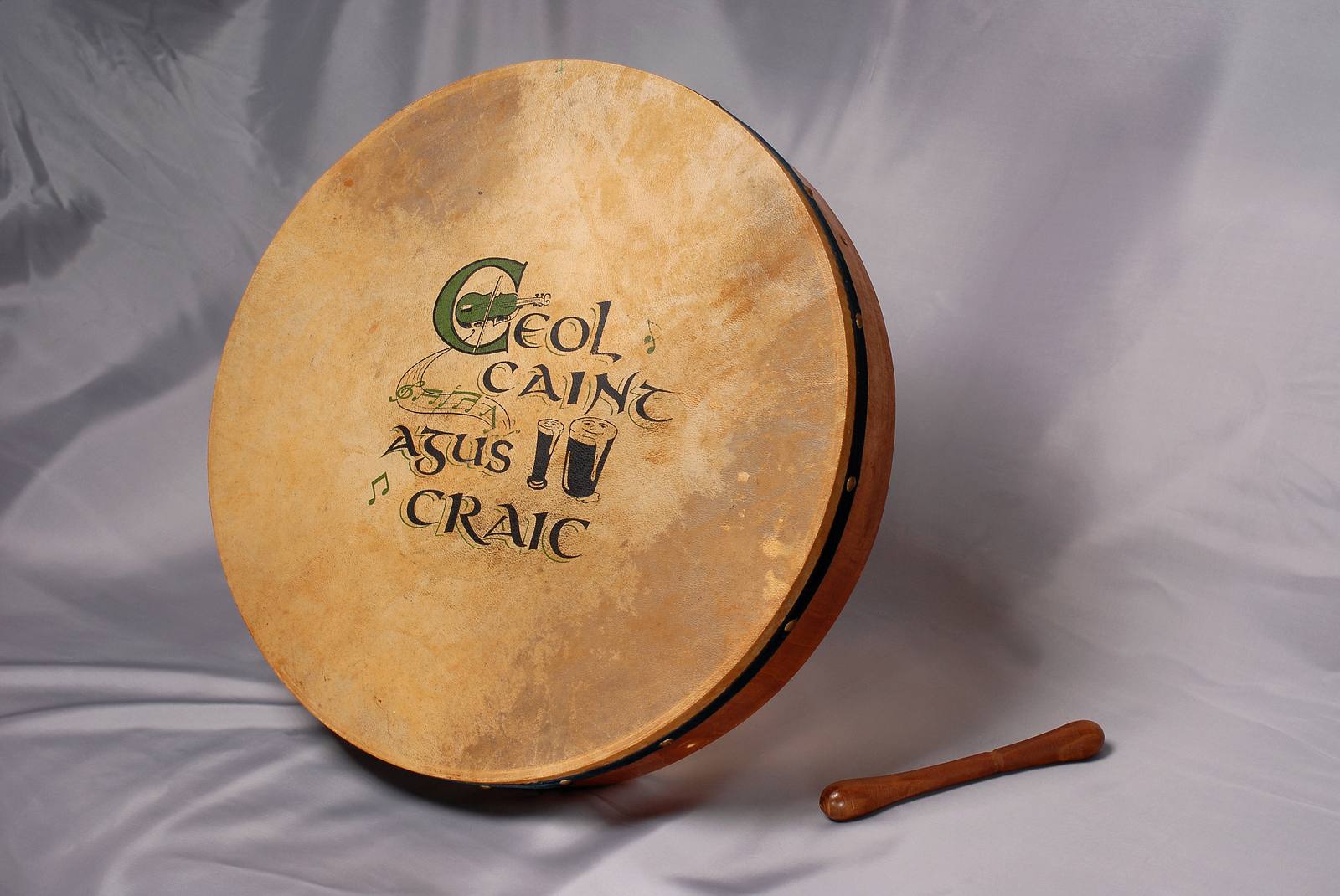 Bodhran drum with Ceol Caint Agus Craic design and a tipper beater