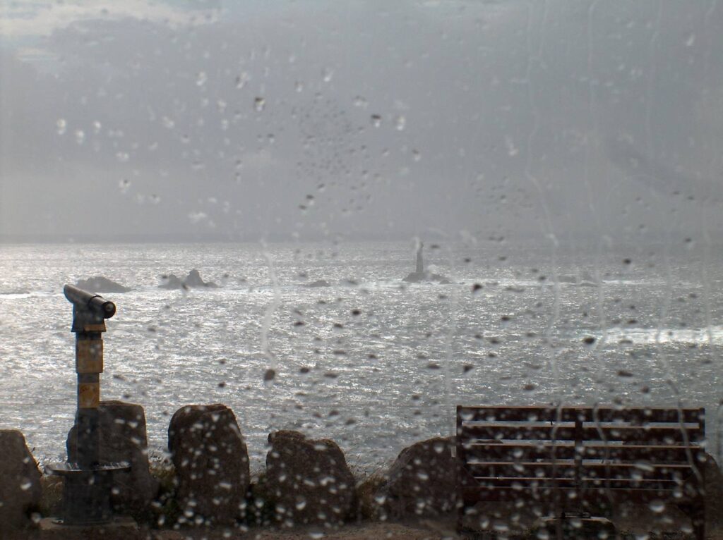 Raindrops and streaks on a window looking out at a grey day
